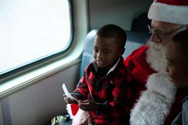A child with Santa on a train.