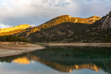 cave lake state park in nevada at sunset, sparsely forested mountain reflecting off of the water