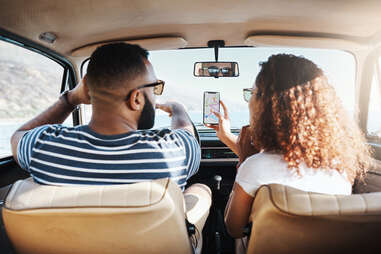 2 people in car looking at phone
