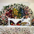 An Episcopalian leads a church service in front of a rainbow of flowers