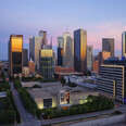 dallas skyline at dusk, featuring skyscrapers downtown in front of a pink and blue sunset